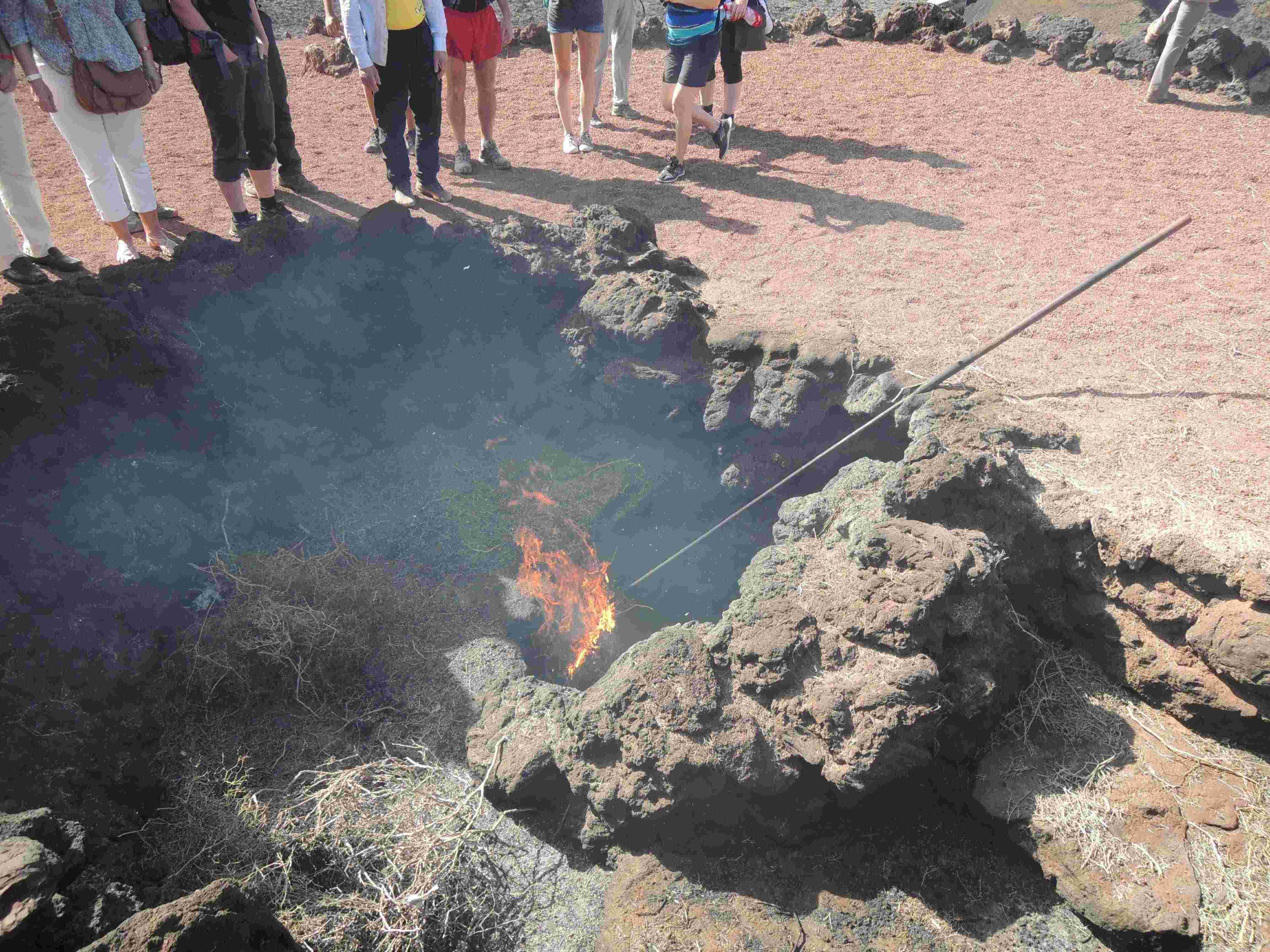 Tourists are shown how sagebrush in a hole close to hot lava will burn